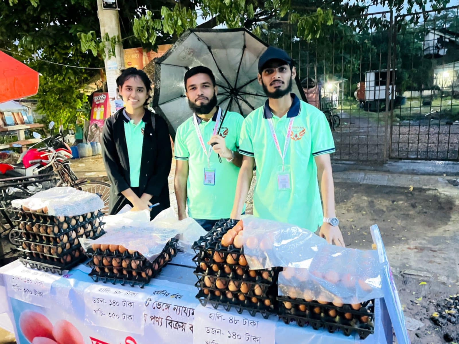 রাজশাহীতে বৃষ্টিতে ভিজে স্বল্পমূল্যে ডিম বিক্রি করছেন স্বেচ্ছাসেবী সংগঠনের তরুণ তরুণী